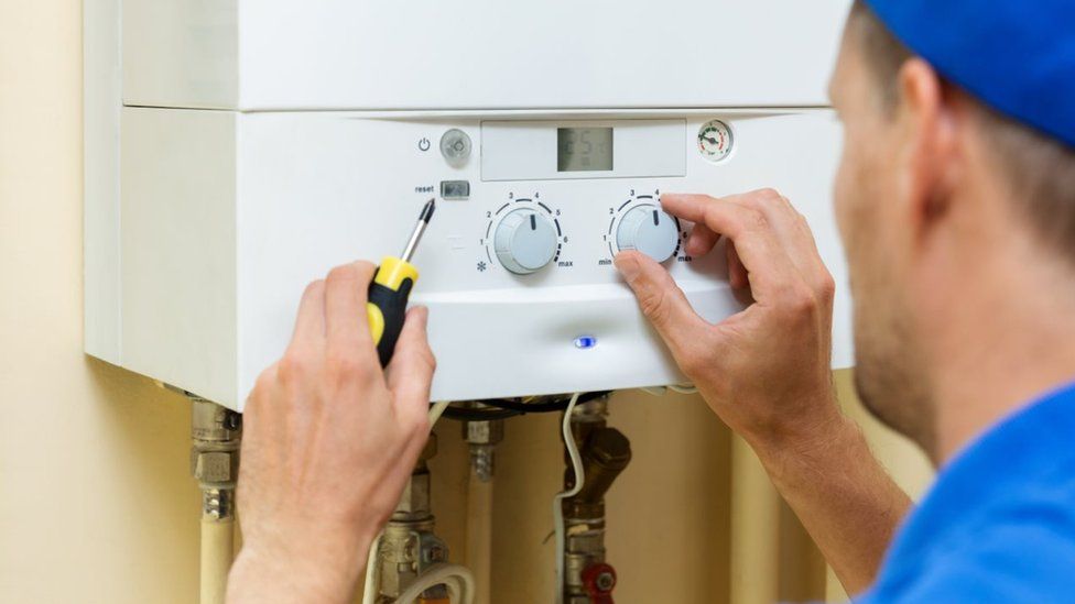 Central heating boiler being fitted by gas expert